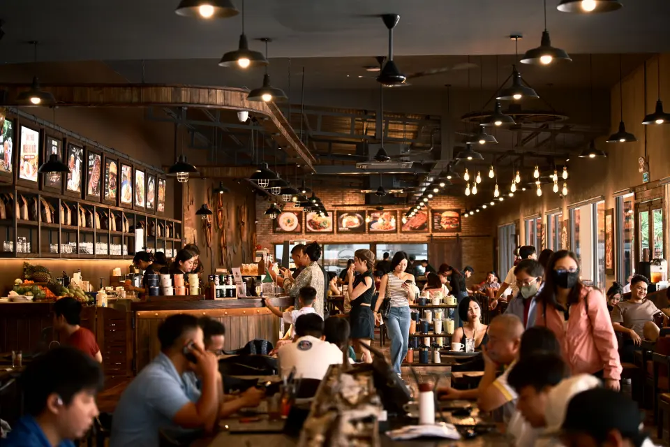 Guests dining in a busy restaurant with an open service counter